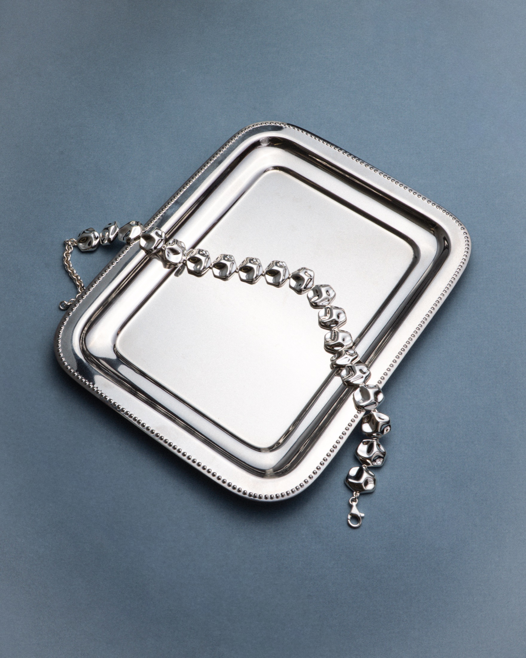 Mara Paris silver necklace on a metal tray